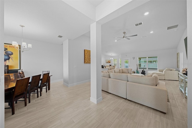 living room featuring ceiling fan with notable chandelier and light hardwood / wood-style flooring