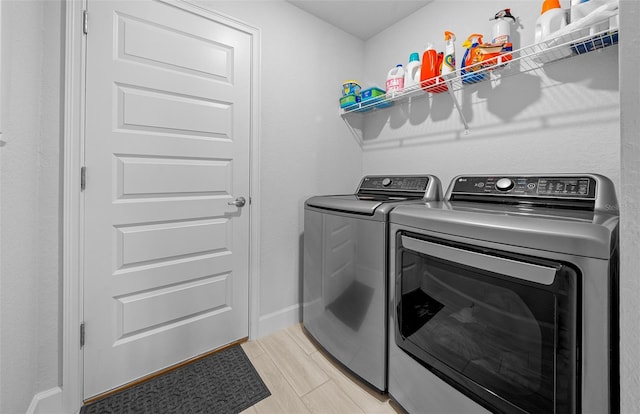 washroom featuring separate washer and dryer and light hardwood / wood-style flooring