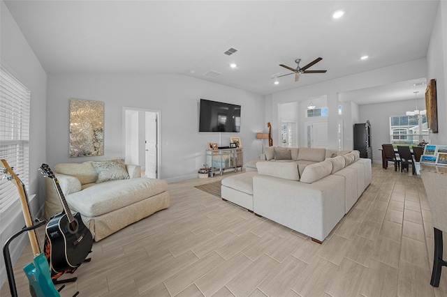 living room featuring ceiling fan, lofted ceiling, and light wood-type flooring