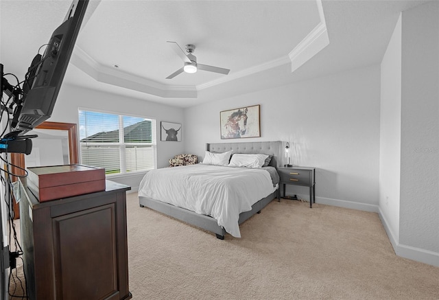 bedroom featuring ceiling fan, a raised ceiling, and light colored carpet