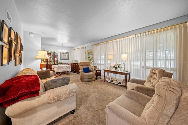 carpeted living room featuring a notable chandelier and a textured ceiling