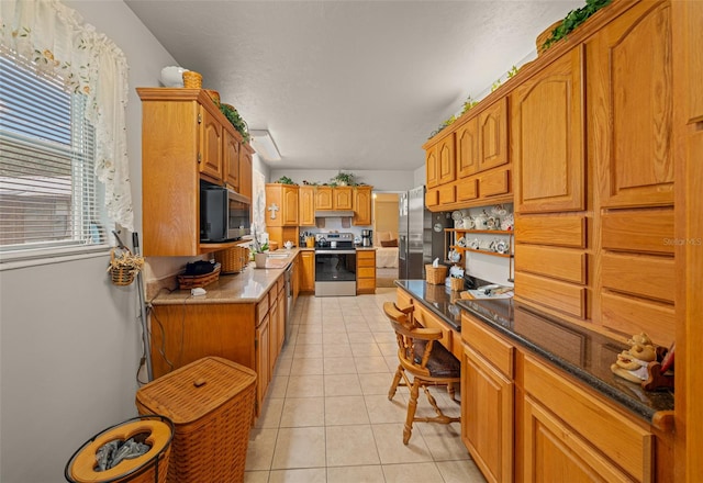 kitchen with appliances with stainless steel finishes and light tile patterned floors