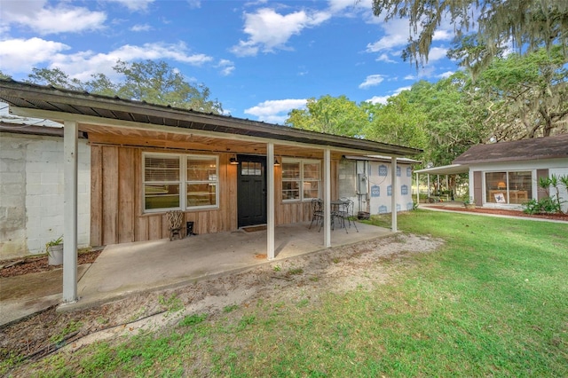 rear view of property with a lawn and a patio