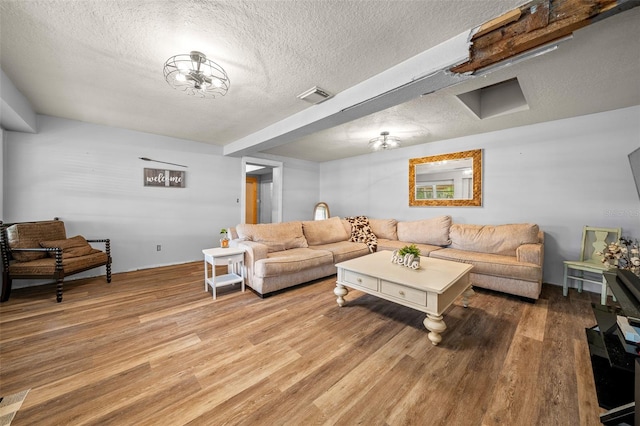 living room with wood-type flooring and a textured ceiling