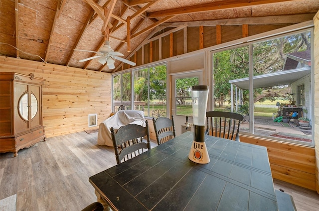 sunroom / solarium with ceiling fan, lofted ceiling with beams, and a wealth of natural light