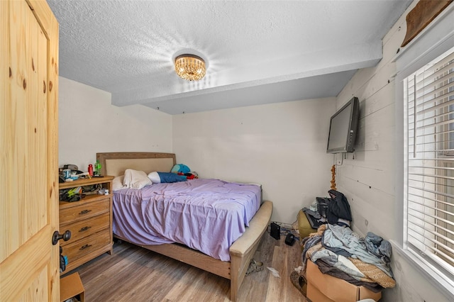 bedroom with a textured ceiling and dark hardwood / wood-style floors