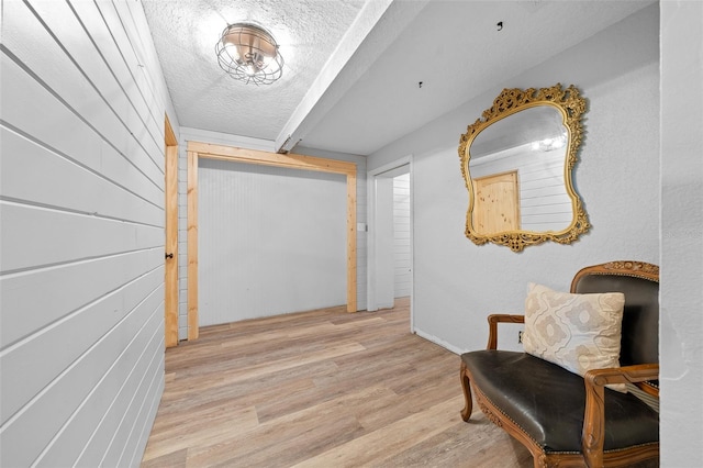 hallway featuring light hardwood / wood-style flooring and a textured ceiling