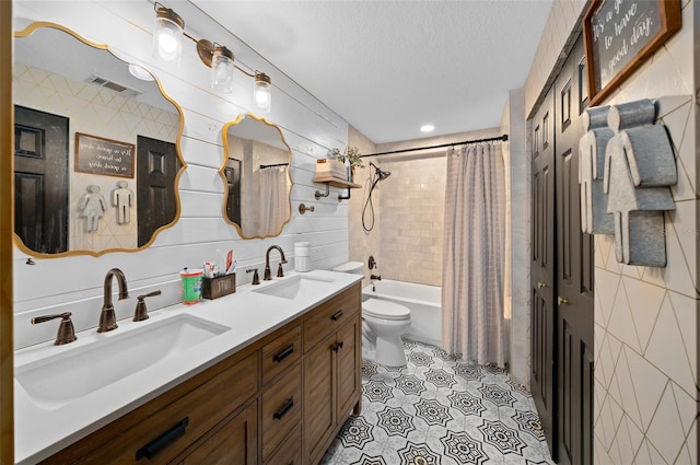 full bathroom with vanity, a textured ceiling, tile walls, toilet, and shower / tub combo with curtain