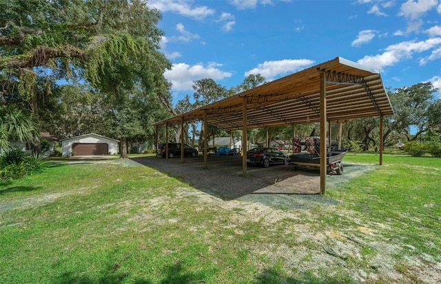 view of yard featuring a carport, an outdoor structure, and a garage