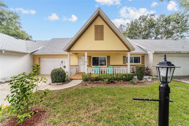 view of front of house featuring a front yard, a garage, and covered porch