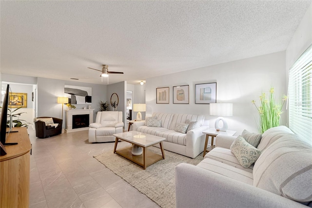 living room with ceiling fan and a textured ceiling