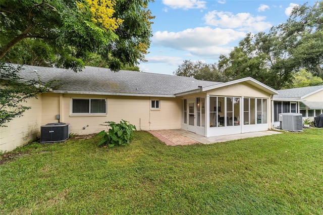 back of house featuring a sunroom, central AC unit, and a yard