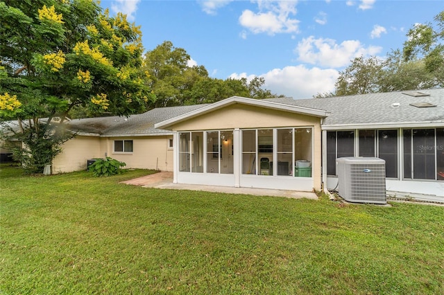 rear view of property featuring a sunroom, central AC unit, and a lawn