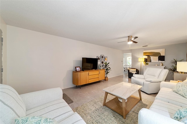 living room with a textured ceiling and ceiling fan