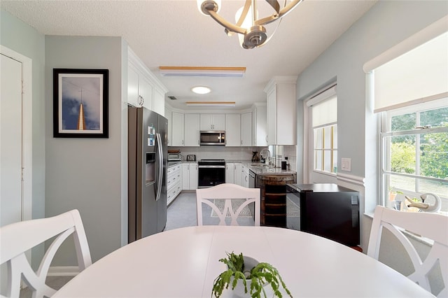 dining area featuring a notable chandelier, a textured ceiling, and sink