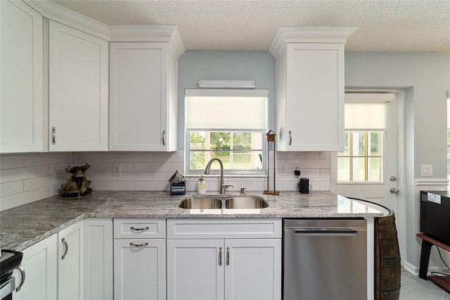 kitchen with light stone counters, sink, tasteful backsplash, white cabinetry, and appliances with stainless steel finishes