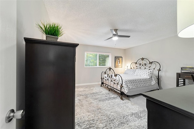 bedroom with ceiling fan and a textured ceiling