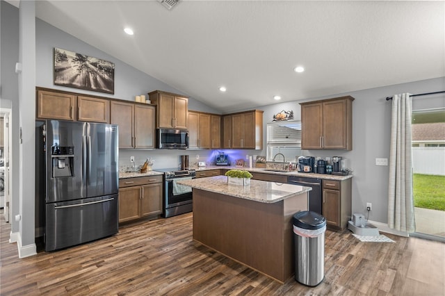 kitchen featuring a center island, dark wood-type flooring, sink, lofted ceiling, and stainless steel appliances