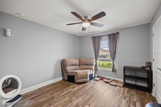 living area with ceiling fan and hardwood / wood-style floors