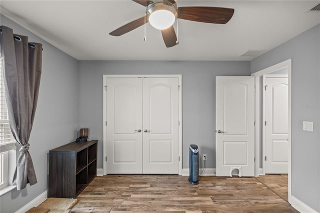 unfurnished bedroom with a closet, ceiling fan, and hardwood / wood-style floors