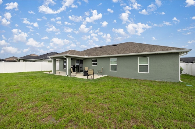 back of property featuring a lawn and a patio