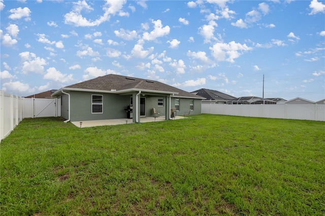 back of house featuring a patio and a yard