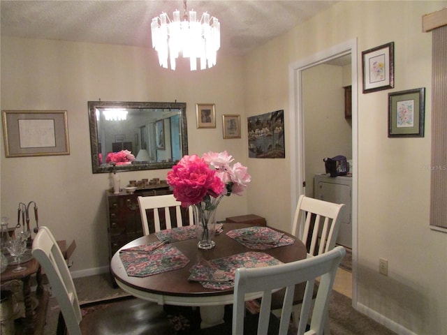 dining room featuring carpet, a textured ceiling, washer / clothes dryer, and an inviting chandelier