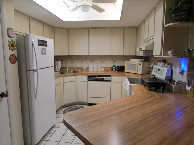 kitchen featuring butcher block countertops, decorative backsplash, sink, and white appliances