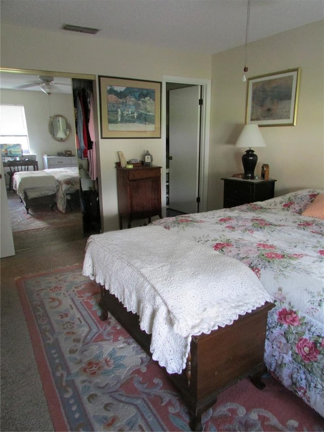 bedroom with dark carpet, a closet, and ceiling fan