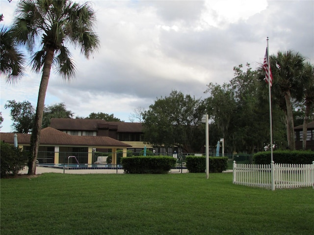 view of property's community with a lawn and a pool