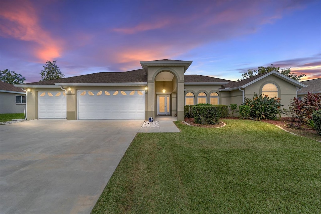 5159 NW 18th St, Ocala, FL 34482 - view of front of property featuring an attached garage, a yard, driveway, and stucco siding