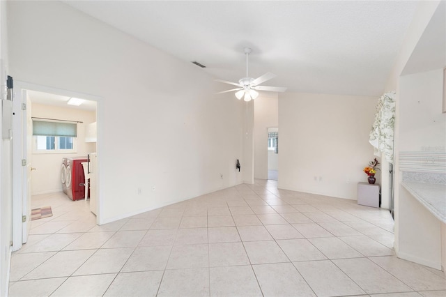 unfurnished room with vaulted ceiling, ceiling fan, and light tile patterned floors