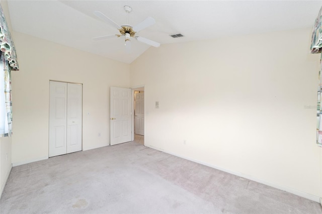 unfurnished bedroom with lofted ceiling, light carpet, ceiling fan, and a closet