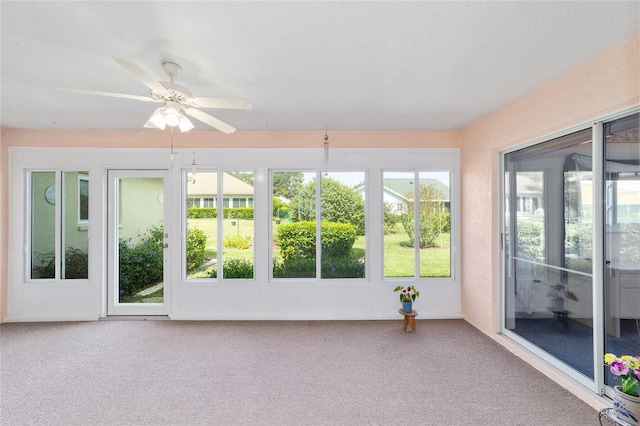 unfurnished sunroom with ceiling fan