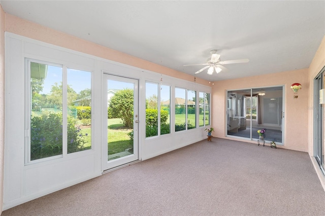 unfurnished sunroom with ceiling fan