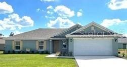 ranch-style house with an attached garage, a front lawn, and concrete driveway