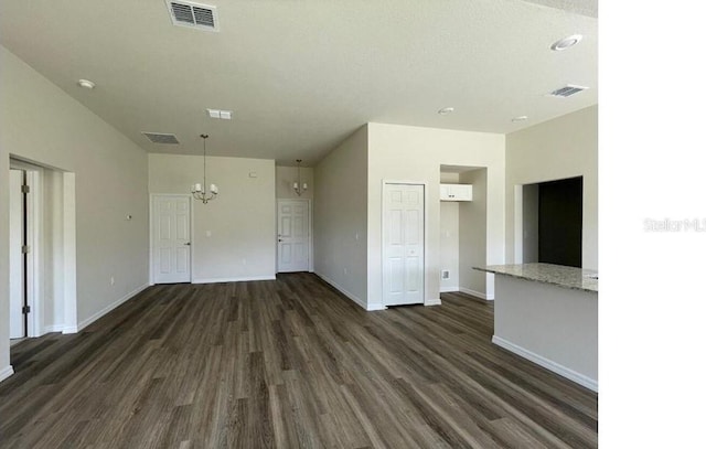 interior space with baseboards, visible vents, and dark wood-type flooring