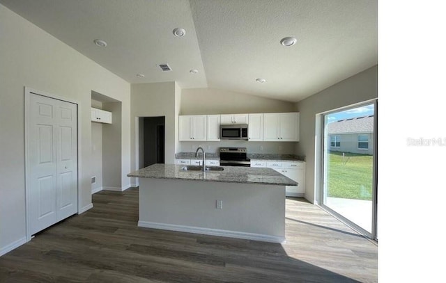 kitchen with light stone counters, a center island with sink, appliances with stainless steel finishes, white cabinetry, and a sink