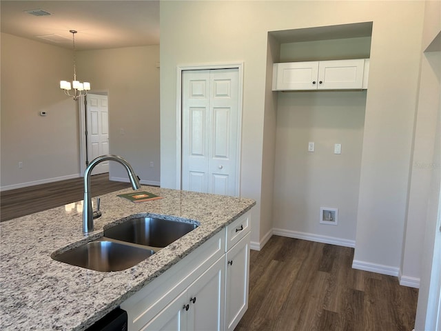 kitchen featuring visible vents, decorative light fixtures, light stone countertops, white cabinetry, and a sink