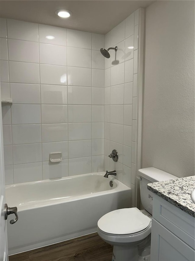 bathroom featuring vanity, shower / washtub combination, wood finished floors, and toilet