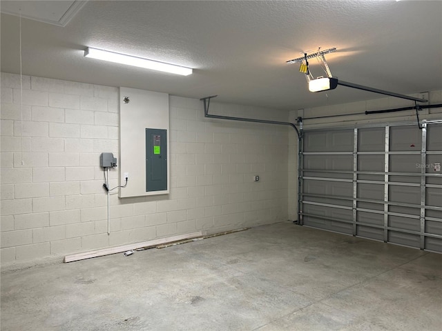 garage with concrete block wall, electric panel, and a garage door opener