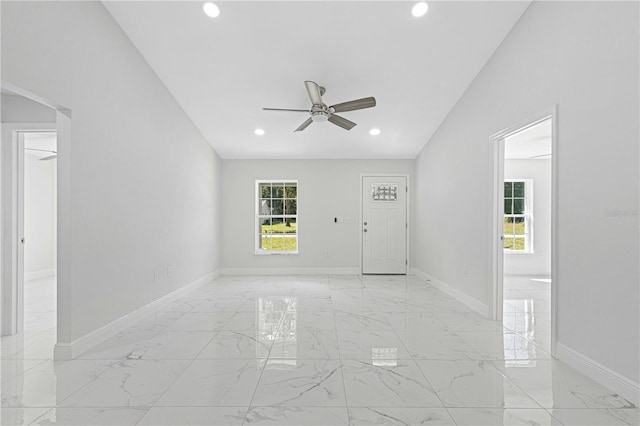 empty room with ceiling fan and vaulted ceiling