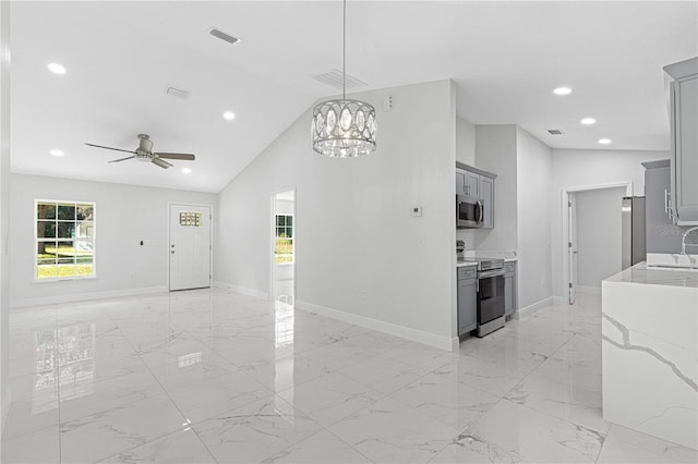 interior space featuring vaulted ceiling, plenty of natural light, sink, and ceiling fan with notable chandelier