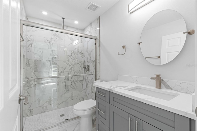 bathroom with an enclosed shower, vanity, and toilet