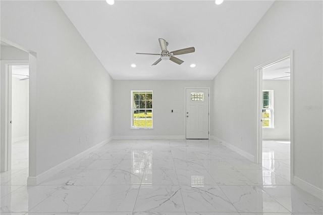 foyer entrance with ceiling fan and lofted ceiling