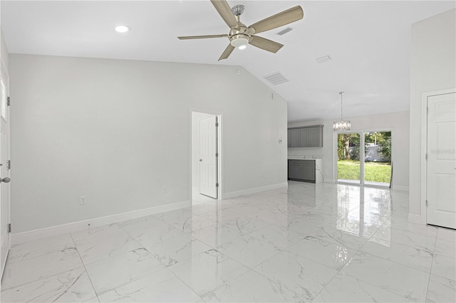 unfurnished living room with vaulted ceiling and ceiling fan with notable chandelier