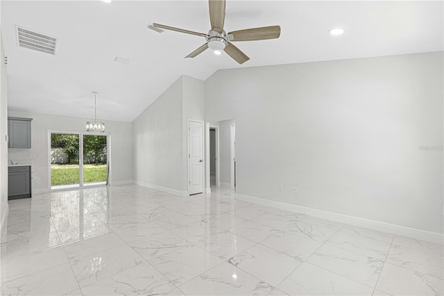 unfurnished room featuring vaulted ceiling and ceiling fan with notable chandelier