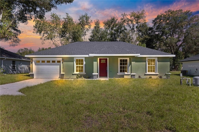 ranch-style home with a garage and a yard