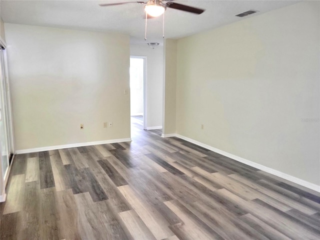 unfurnished room with ceiling fan and dark wood-type flooring