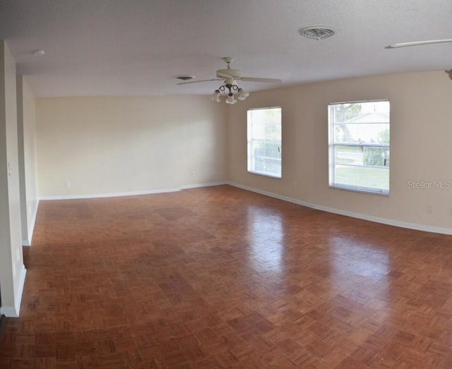 spare room featuring dark parquet floors, a textured ceiling, and ceiling fan